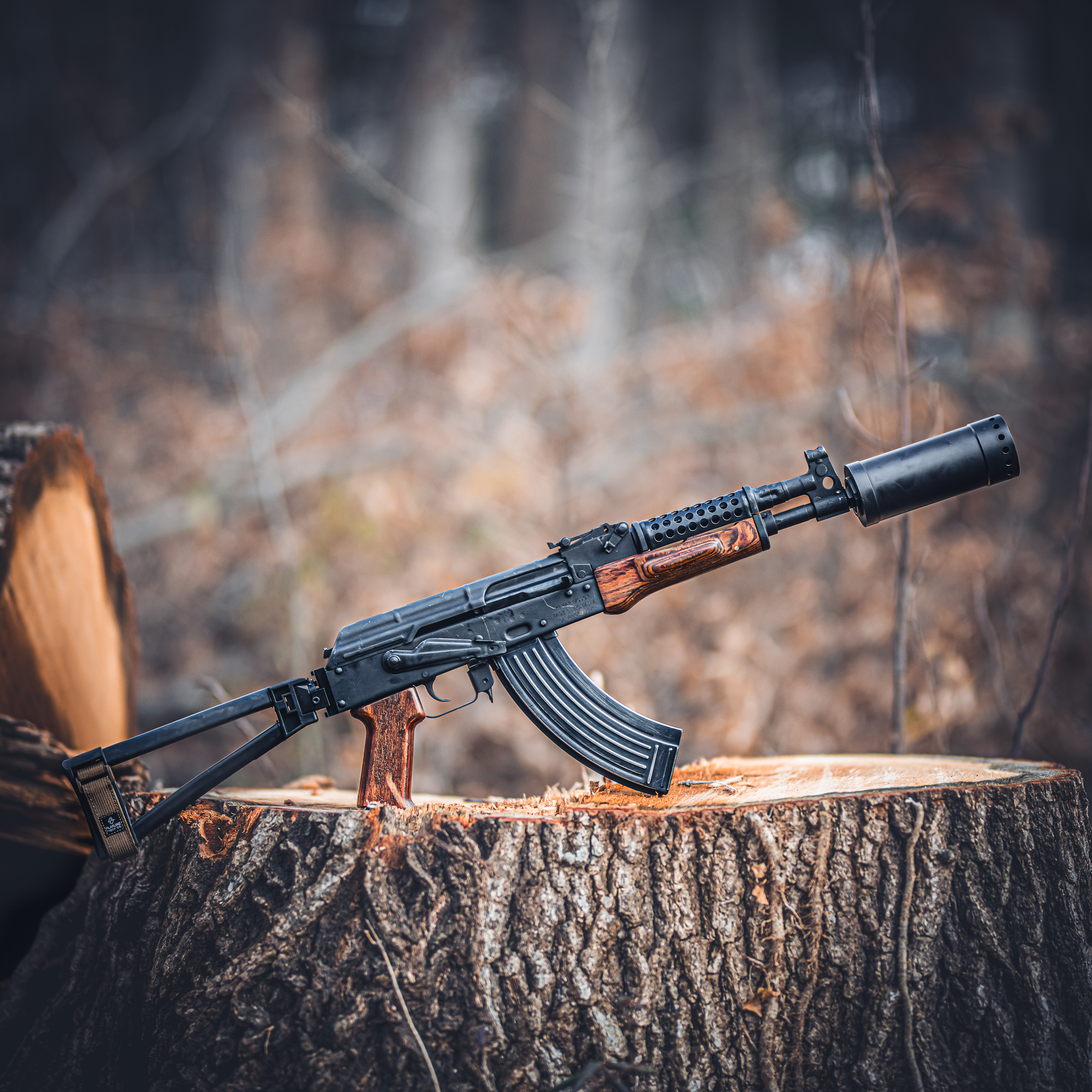 Suppressed rifle on a tree stump